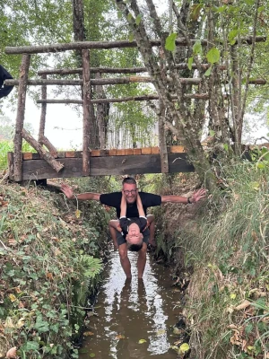 Moment ludique dans l’eau sous un pont en bois sur le sentier pieds nus du Domaine de Larrous – Domaine de Larrous, Gaujacq (Landes)