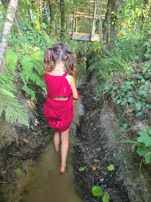 Enfant marchant pieds nus dans la boue sur le sentier pieds nus du Domaine de Larrous – Domaine de Larrous, Gaujacq (Landes)